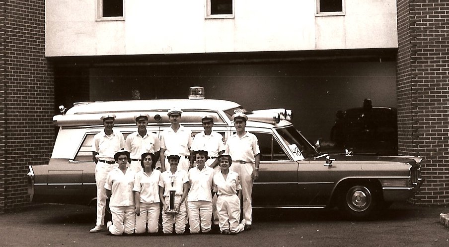 Squad members with a 1960's Caddilac ambulance